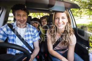 Smiling family sitting in the car