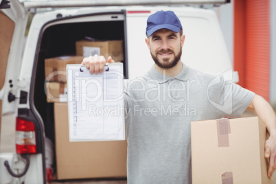 Delivery man holding clipboard an package