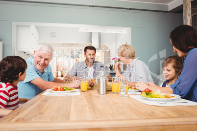 Family with grandparents discussing at dining table