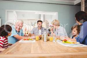 Family with grandparents discussing at dining table