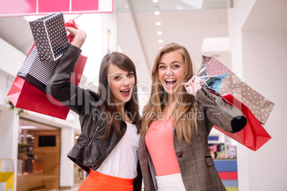 Portrait of two excited women with shopping bags