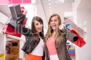 Portrait of two excited women with shopping bags