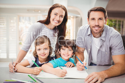 Portrait of smiling family writing in book Portrait of smiling family writing in book