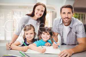 Portrait of smiling family writing in book