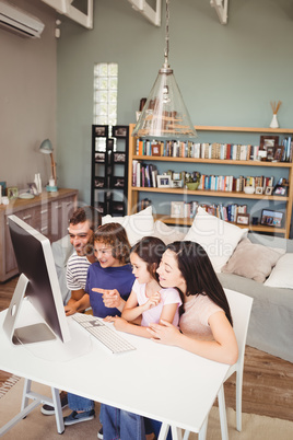 Cheerful family using computer at home