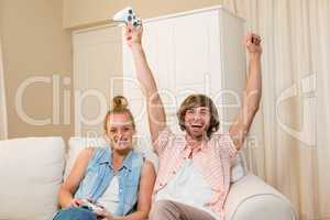 Cute couple playing video games sitting on the couch