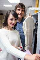 Portrait of couple selecting a dress while shopping for clothes