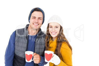Smiling couple holding mug and looking the camera