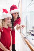 Mother and daughter in Christmas attire looking at jewelry displ