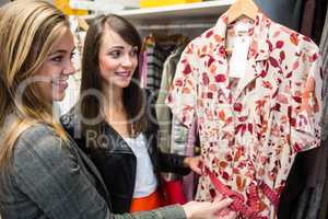 Women selecting a dress while shopping for clothes