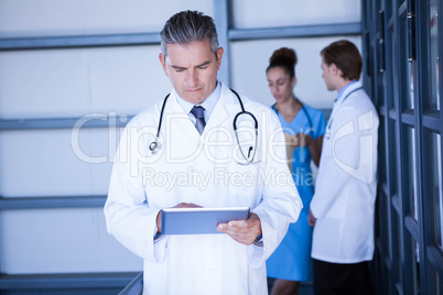 Male doctor looking at digital tablet in hospital