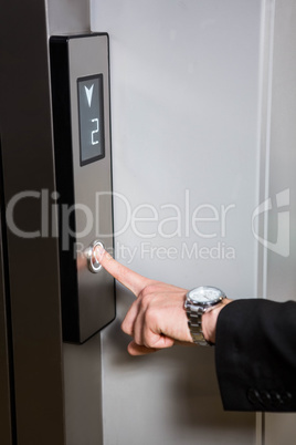 Businessman pressing elevator button