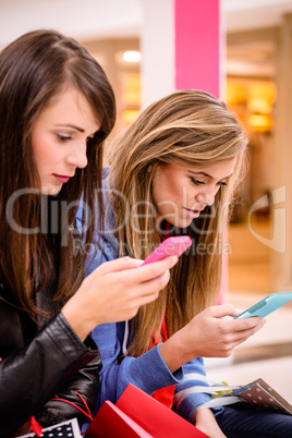 Two beautiful women using their phone