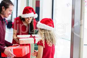 Parents giving Christmas gifts to their daughter
