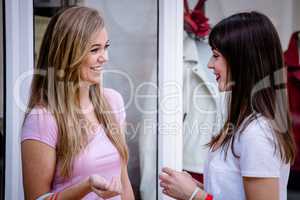 Two beautiful women talking outside a shop