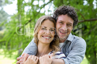 Smiling couple embracing in park