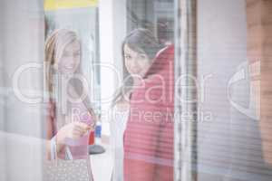Two beautiful women window shopping in mall