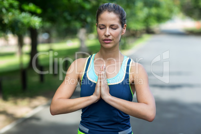 Sportswoman meditating with hands joined
