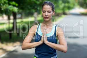 Sportswoman meditating with hands joined