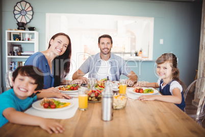 Portrait of smiling family with food on dining table