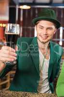 Man with a hat toasting a beer