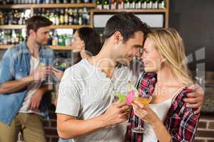 Couple toasts with cocktails