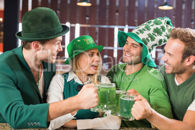 Friends wearing St. Patricks day associated clothes toasting