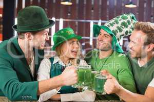 Friends wearing St. Patricks day associated clothes toasting