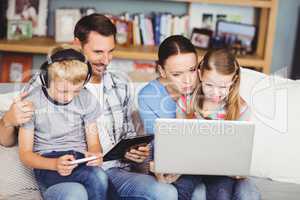 Family using technologies on sofa