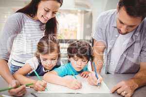 Family writing in book while standing at table