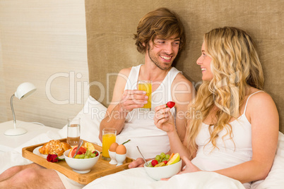 Cute couple having breakfast in bed