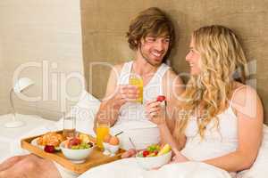 Cute couple having breakfast in bed