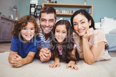 Portrait of happy family lying on carpet