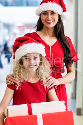 Mother and daughter in Christmas attire standing with Christmas