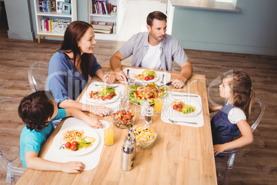 Family discussing with food on dining table