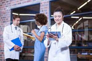 Female doctor using digital tablet near library