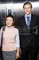 Businessman and businesswoman standing in an elevator