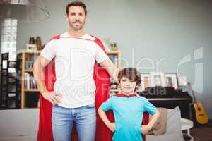 Portrait of smiling father and son in superhero costume