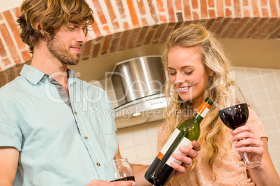 Cute couple enjoying a glass of wine and reading the bottle