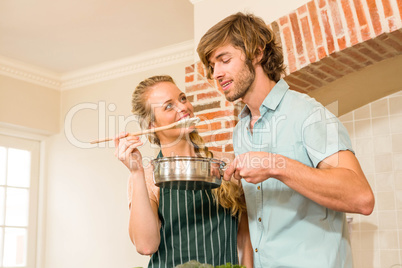 Pretty blonde making her boyfriend taste the preparation