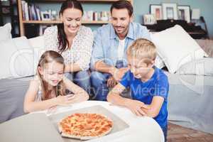 Smiling family with pizza on table
