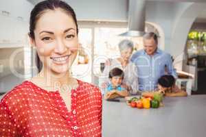 Happy woman with family preparing food in background
