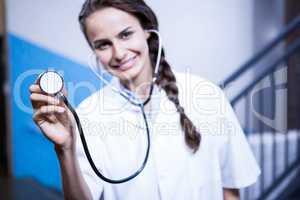 Portrait of female doctor showing stethoscope