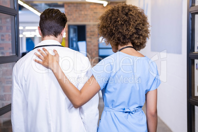 Doctor and nurse walking in hospital corridor