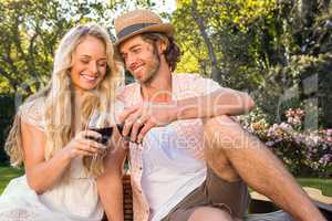 Happy couple having a picnic and drink red wine