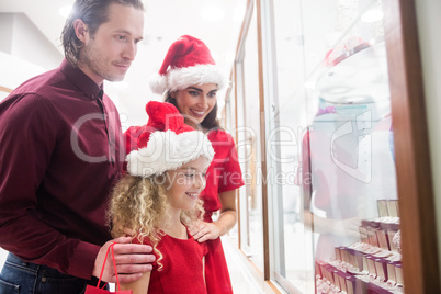 Family in Christmas attire looking at jewelry display