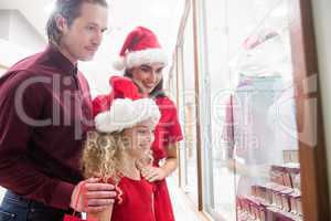 Family in Christmas attire looking at jewelry display