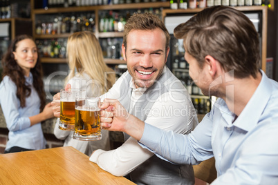 Men toasting in front while women talk behind