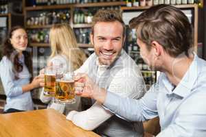 Men toasting in front while women talk behind