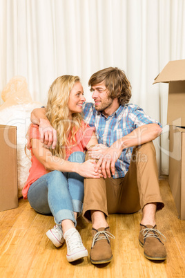 Happy couple sitting on the floor